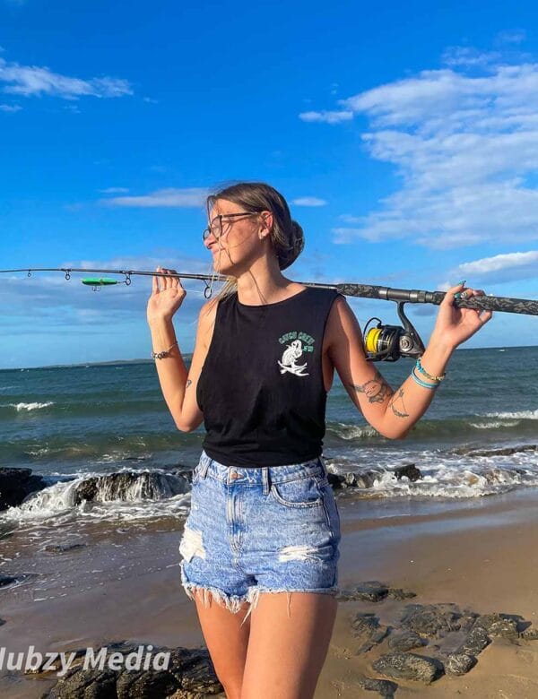 Front view of female wearing Catch Crew N' Co singlet at the beach