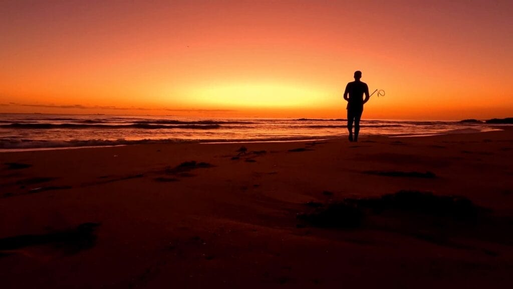 Silhouette of Cain Bergstrom on the beach at sunset